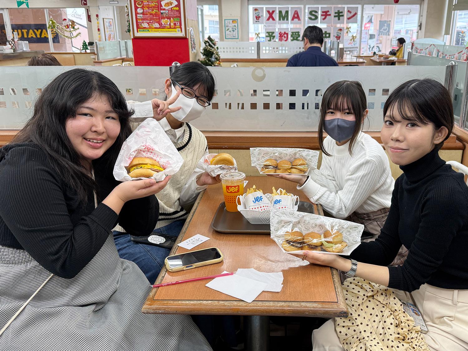 注文したハンバーガーを手に撮影